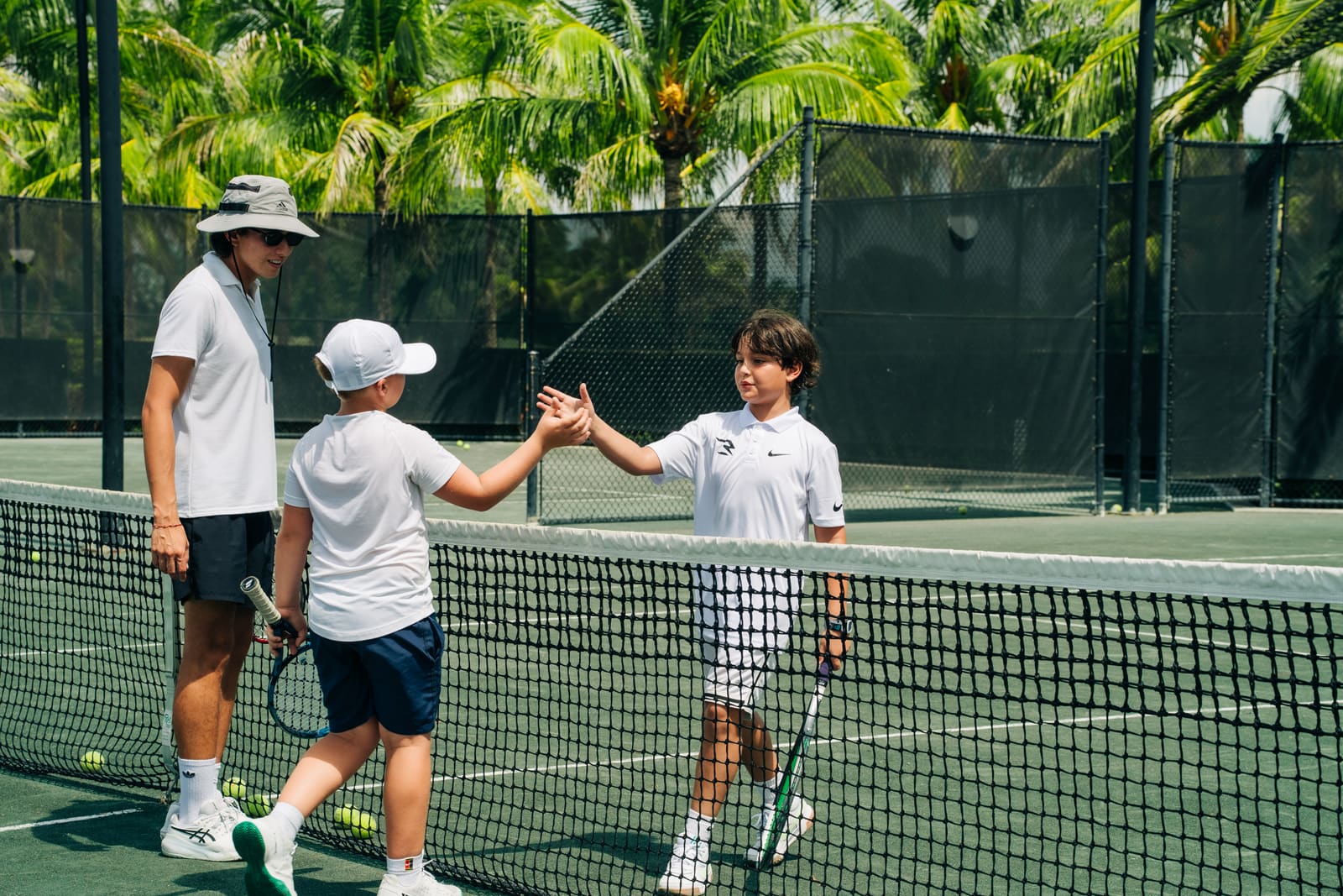 Two juniors shaking hands at the net