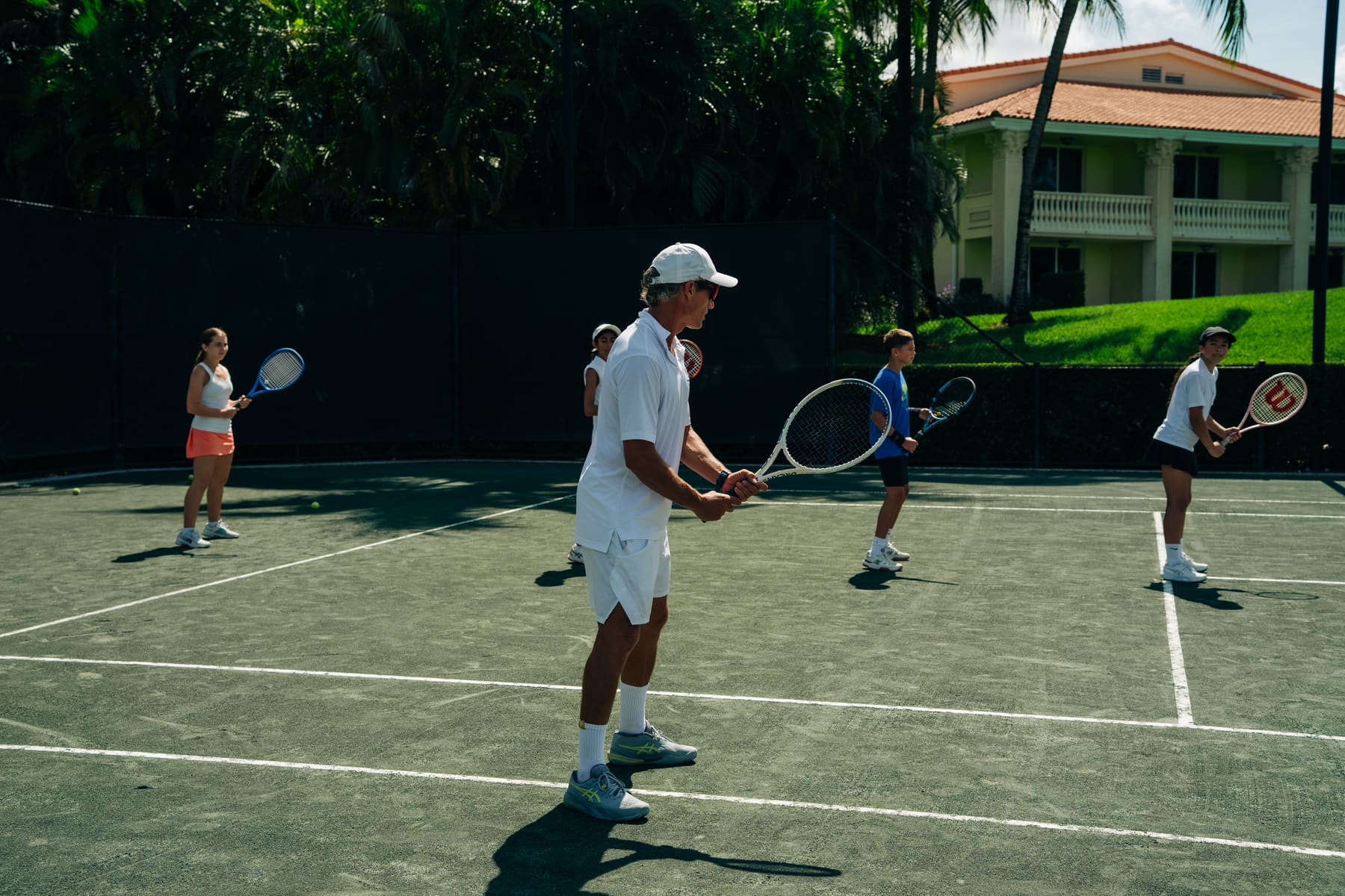 Group clinic on the green courts with the clubhouse behind