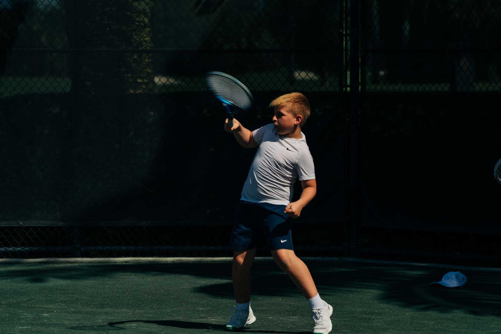 Young junior swinging on the baseline