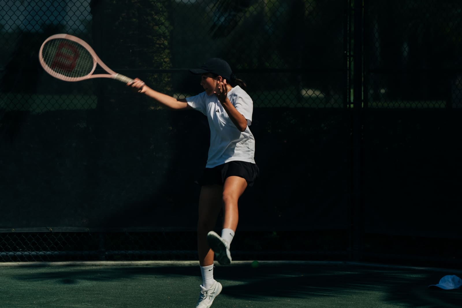 Junior serving against the back fence